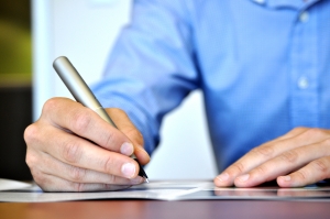 1338212_business_man Man writing with a pen.